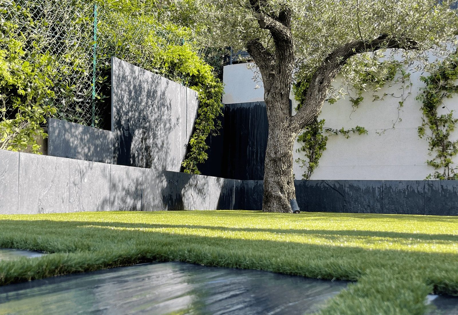 Jardin contemporain avec pelouse et mur en pierre — création de jardin à Saint-Raphaël